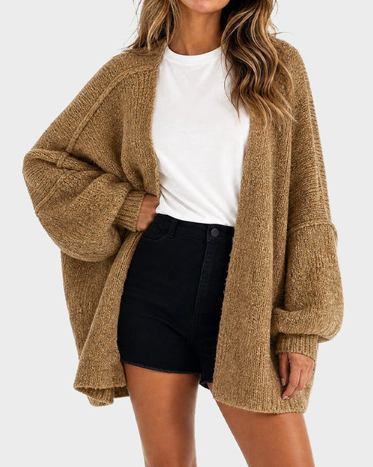 Dame i oversized strikket cardigan med åben front og lange voluminøse ærmer