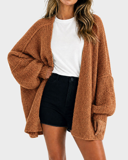 Dame i oversized strikket cardigan med åben front og lange voluminøse ærmer