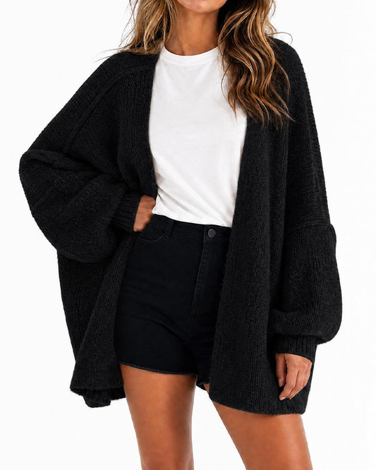 Dame i oversized strikket cardigan med åben front og lange voluminøse ærmer