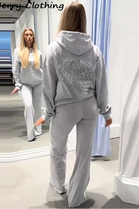Damehoodie med hætte og pailletvinger på ryggen