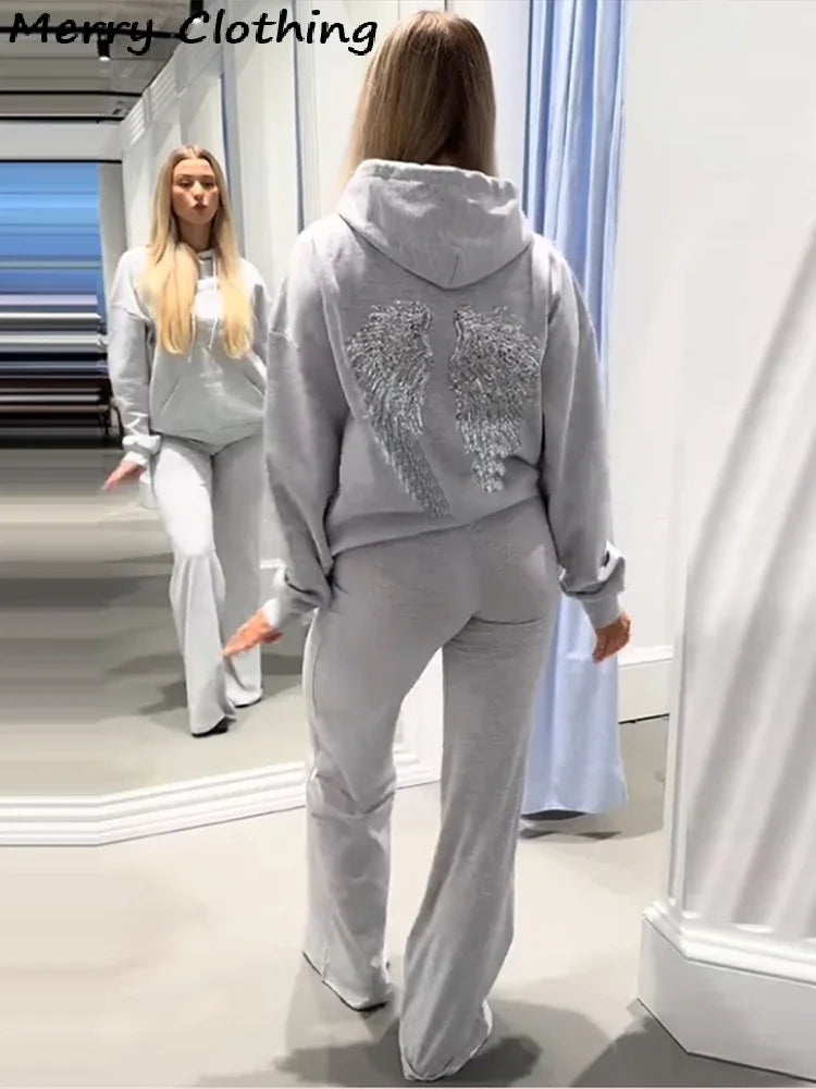 Damehoodie med hætte og pailletvinger på ryggen