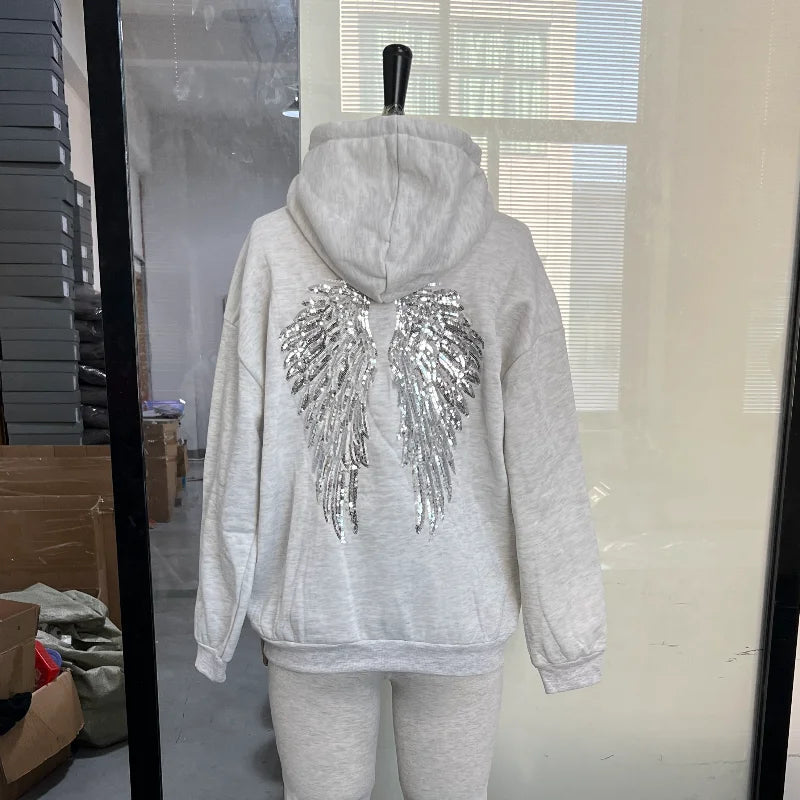 Damehoodie med hætte og pailletvinger på ryggen