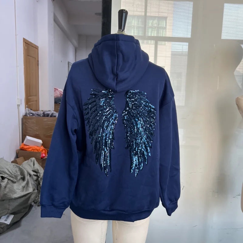 Damehoodie med hætte og pailletvinger på ryggen